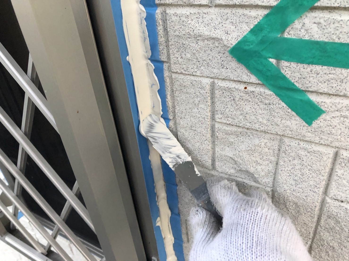 静岡市U様邸でコーキングをヘラで押さえて仕上げている様子