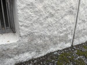 アパートの基礎付近に見られた汚れと細いひび