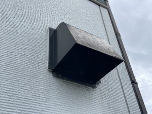アパート外壁に取り付けられた換気フードの汚れと色あせ